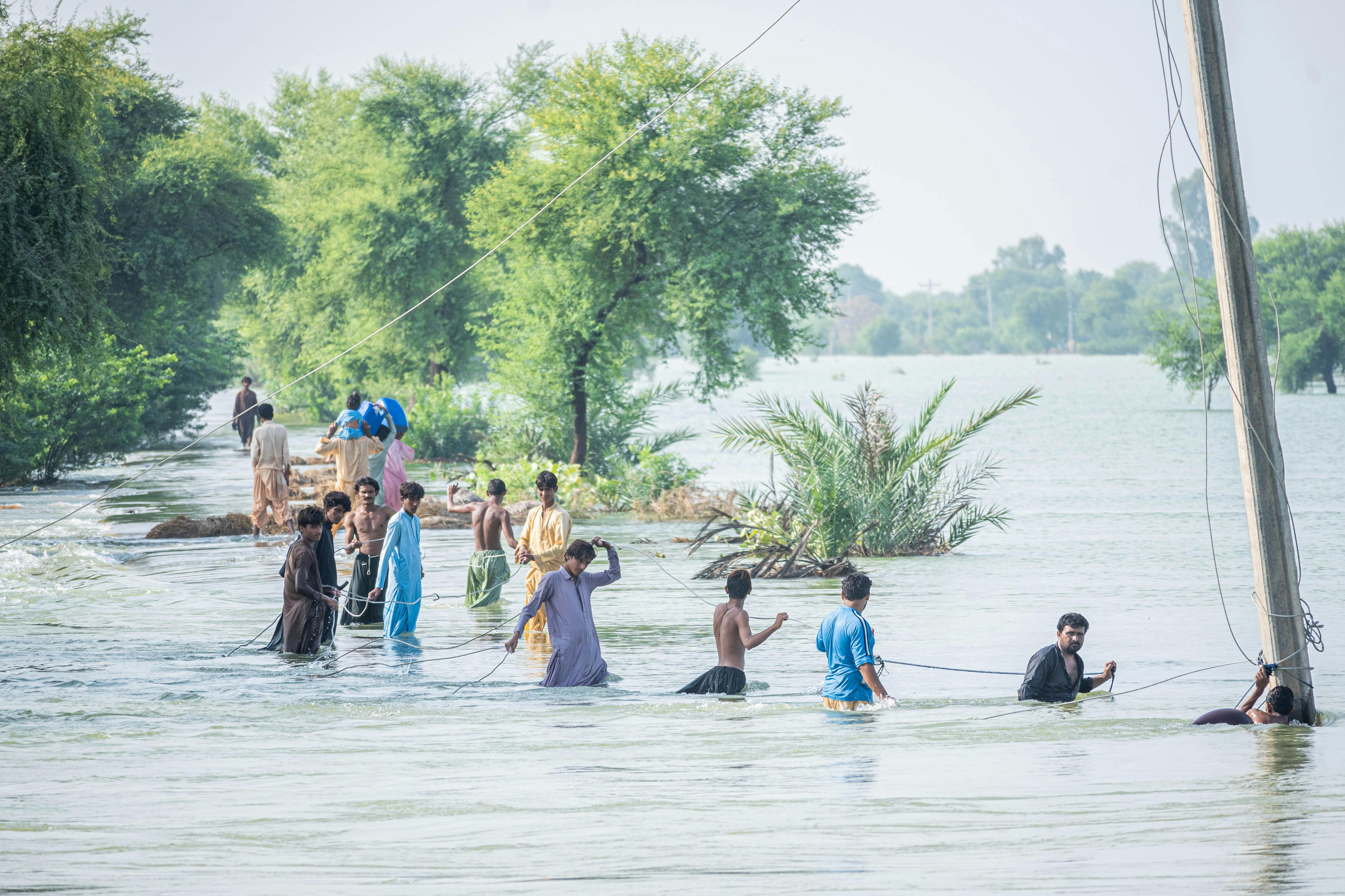 People wading through floodwaters